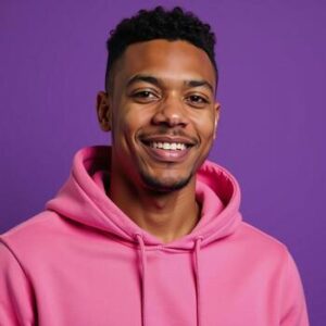 a young africanamerican male poses in isolation smiling while donning a pink hoodie and positioned against a vibrant purple backdrop photo